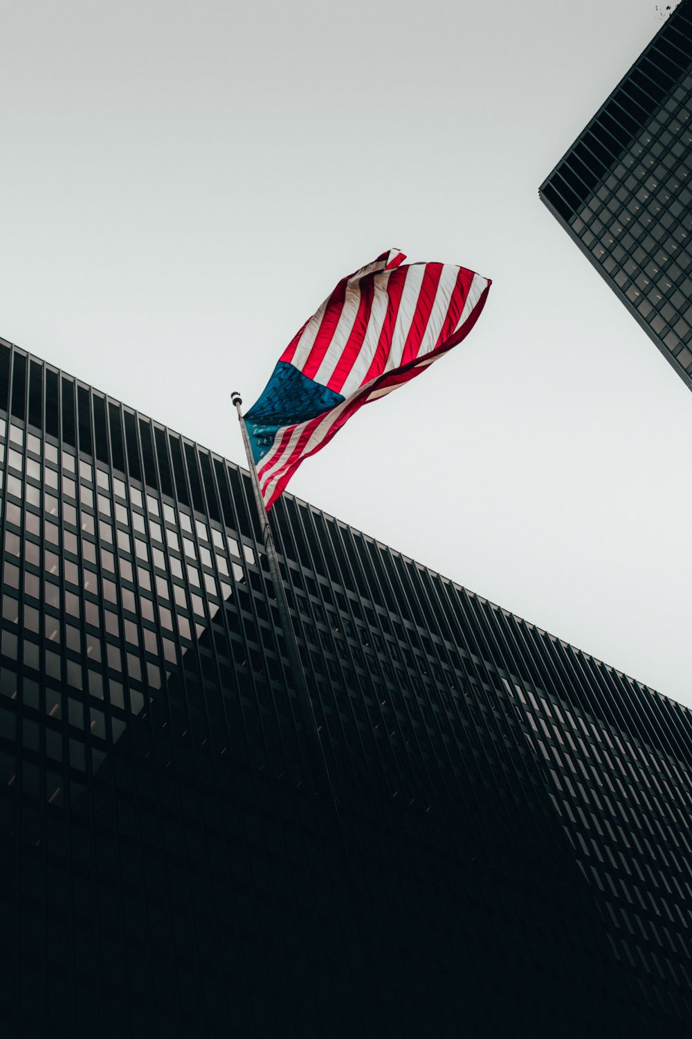 An American flag flying beside modern office buildings